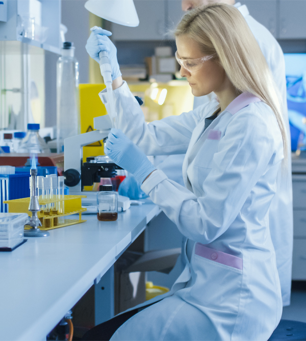 Shot of a Female Genetic Research Scientist Using a Micro Pipette while Working in a Modern High-Tech Laboratory. In the Background Big Monitors Showing DNA Structure.